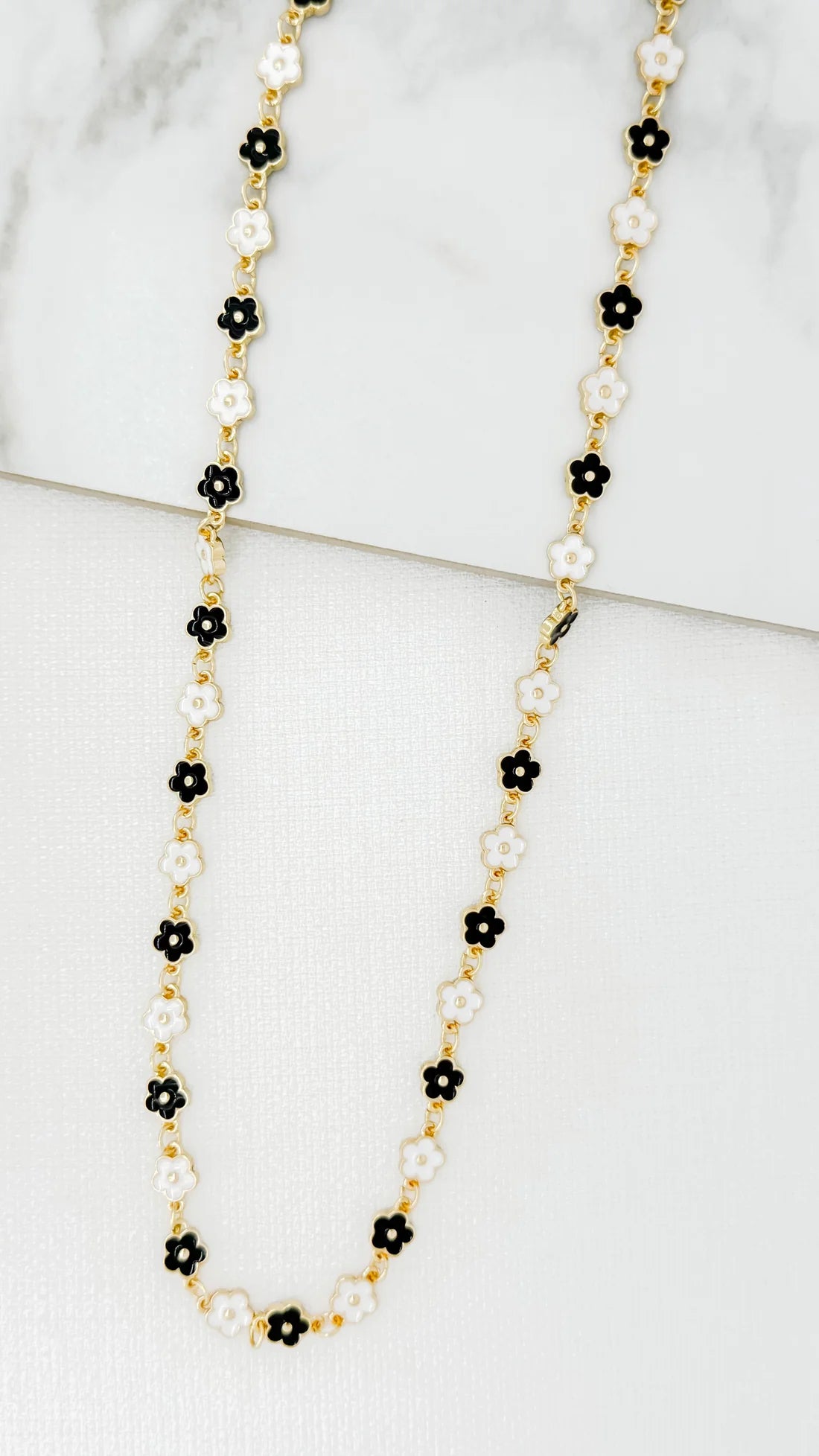 Envy Long gold necklace with black and white enamel daisy design