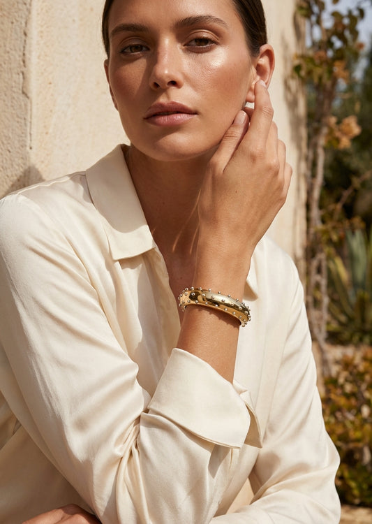 Envy Gold wide cuff bracelet with a sleek band edged in evenly spaced silver spheres