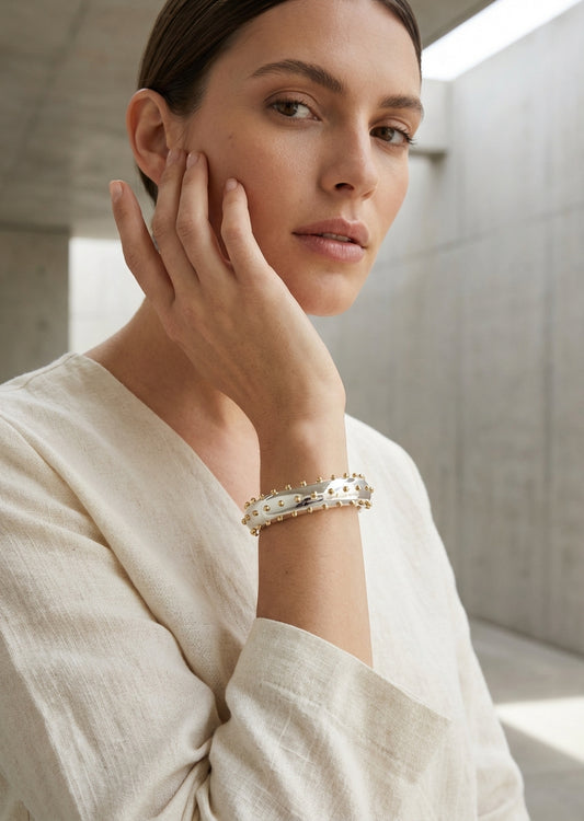 Envy Silver wide cuff bracelet with a sleek band edged in evenly spaced gold spheres